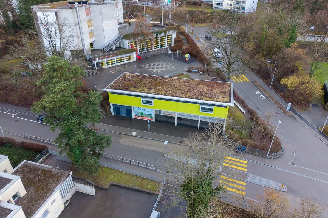 Der heutige Kindergarten (gelb-grünes Haus in der Bildmitte) soll aufgestockt werden. Der Kindergarten zügelt auf die andere Strassenseite (Gebäude unten links).