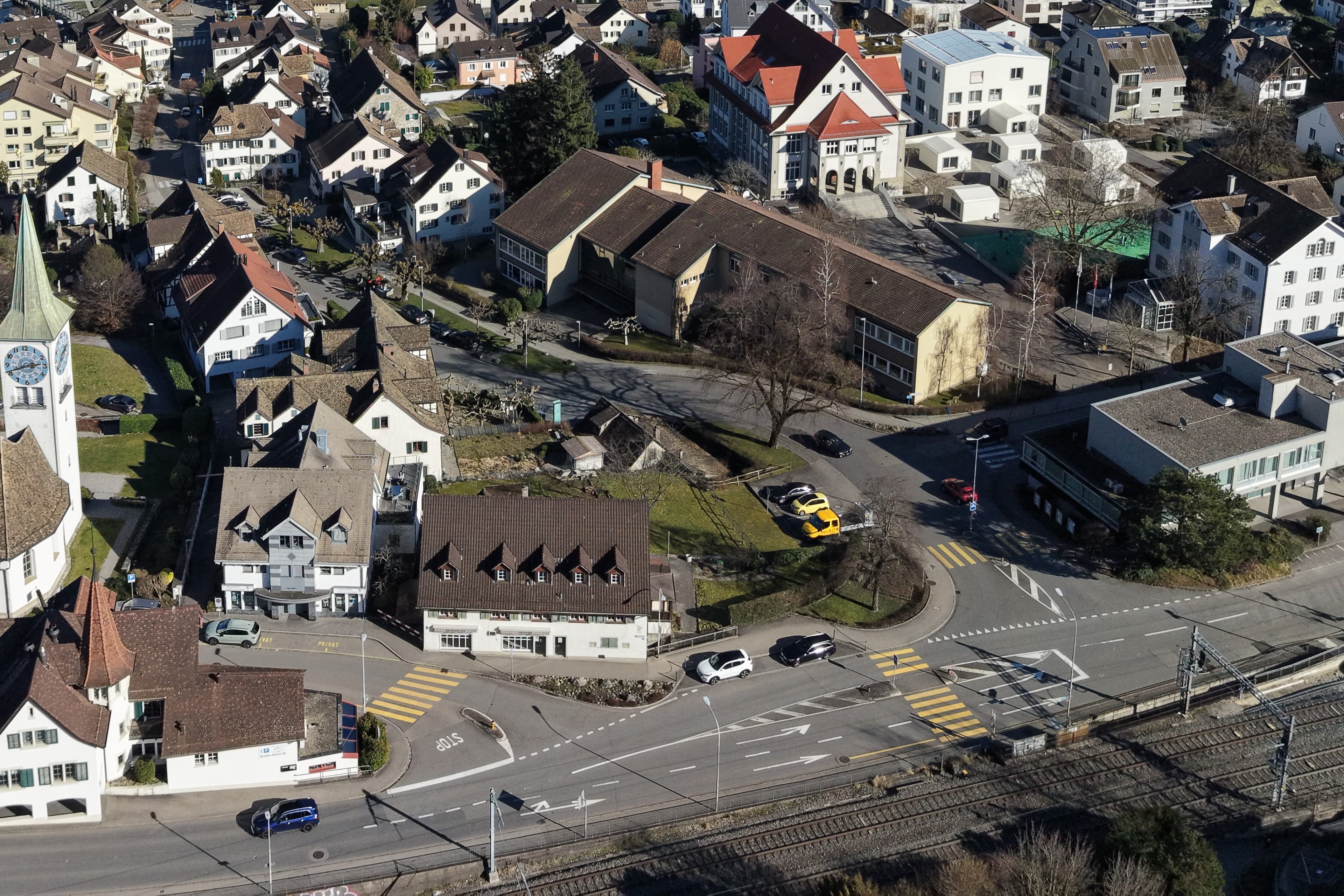 Die Strassen im mehrspurigen Kreuzungsbereich von Bahnhofstrasse und Dorfstrasse werden schmaler, die Trottoirs breiter. Parkplätze entstehen entlang der Geleise (unten).