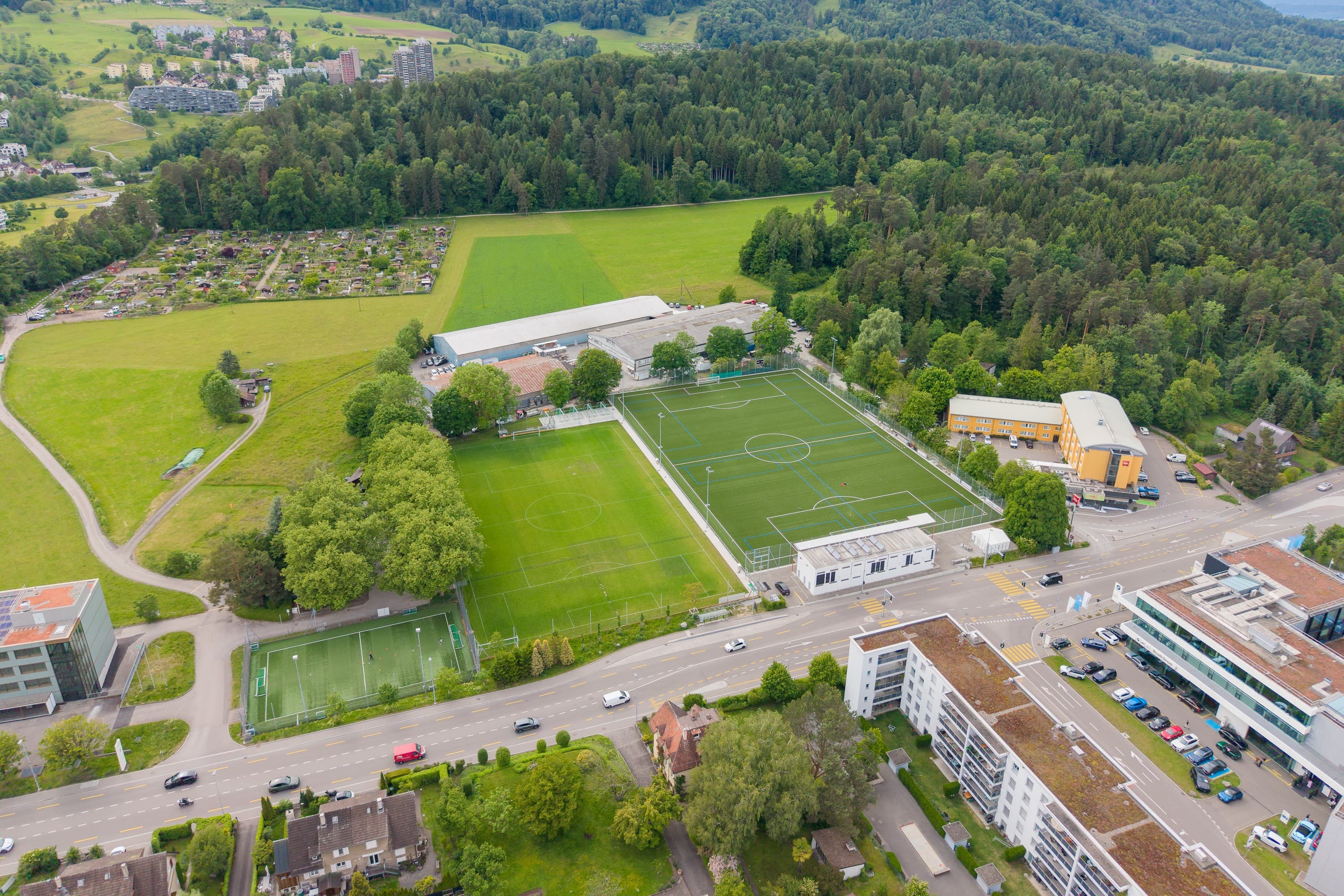 Das weitgehend unbebaute Gebiet Sunnau mit den Fussballplätzen an der Zürichstrasse und dem Erholungsgebiet samt Familiengärten am Rand des Entlisbergwalds. Rechts das gelbe Ibis Hotel.