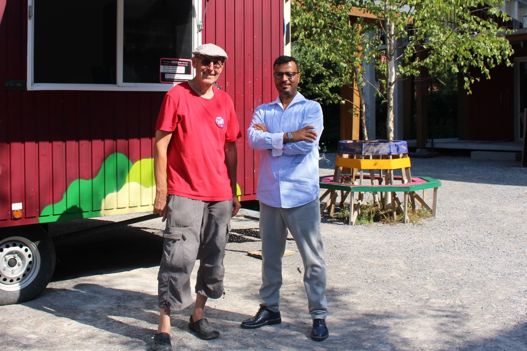 Scander Mohamed (rechts) und vor dem Quartier-Mobil, das im Durchgangszentrum Sihlau für zwei Wochen seine Türen öffnet.
