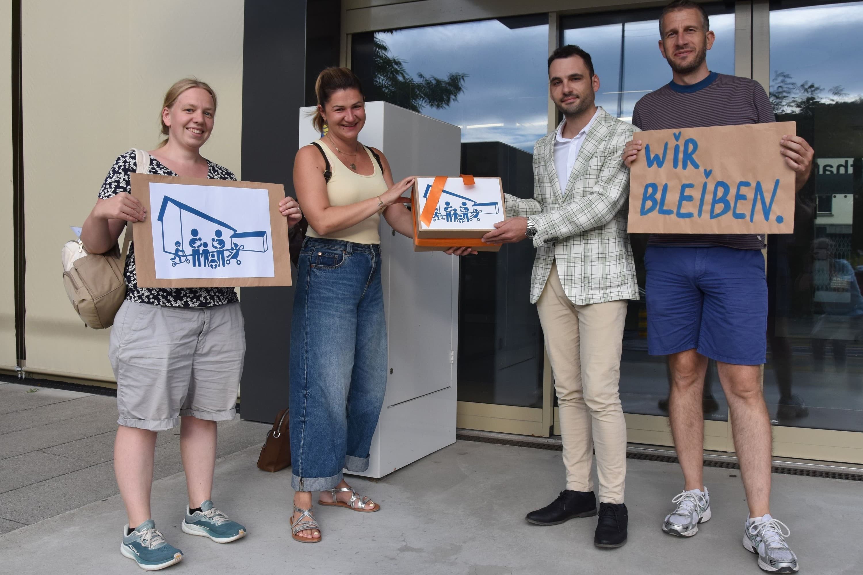 Parlamentspräsident Sebastian Huber (SVP, 2.v.l.) nimmt die Petition zum Familienzentrum von (v.l.) Rebekah Steib, Jennifer Dey und Fausto Aloise entgegen.